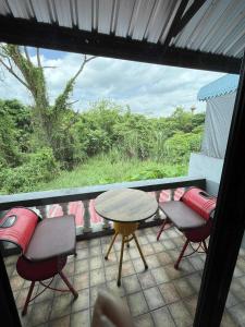 einen Balkon mit Stühlen, einem Tisch und Stühlen in der Unterkunft Wiang Ping house in Chiang Mai + 19 Fotos