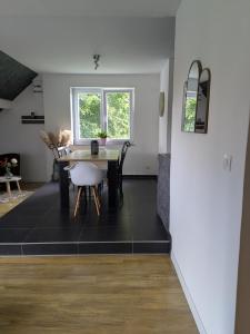 a dining room with a table and chairs at Au jardin des pies in Woustviller