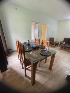 einen Esstisch und Stühle in einem Zimmer in der Unterkunft Ooty Dream Weaver cottage in Udagamandalam