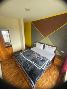 ein Schlafzimmer mit einem Bett mit einer schwarzen Decke darauf in der Unterkunft Ooty Dream Weaver cottage in Udagamandalam