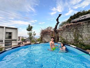 un uomo e un bambino seduti in piscina di Atami Ikyuan 熱海一休庵 ad Atami