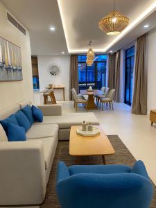 a living room with a white couch and blue chairs at Wyndham Garden 3Br Villa 5star Resort Beachfront in Cam Lâm
