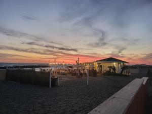 Una puesta de sol en la playa con un restaurante en la playa. en Dream House Fiumicino, en Fiumicino
