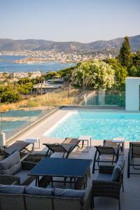 ポルト・ラフティにあるHelios Apartments Porto Raftiのスイミングプール(椅子、テーブル付)