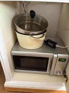 a bowl on top of a microwave with a pot on top at Alpine base near Hallstatt in Bad Goisern