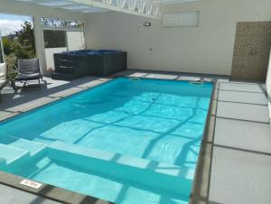 una piscina con agua azul en una casa en Nature Apartment 2 with Pool, en Arco da Calheta