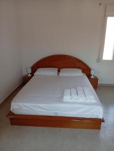 a bedroom with a bed with white sheets and pillows at Tourni Cozy Chios in Chios