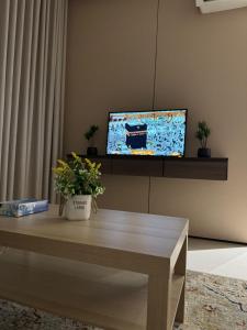 een woonkamer met een tafel en een tv bij ليالي طيبة in Al Madinah