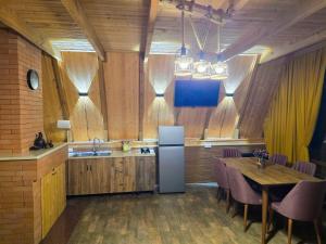 a kitchen with a refrigerator and a table with chairs at Kutaisi Red Water Cottage in Odilauri