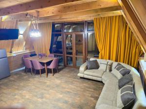 a living room with a couch and a table at Kutaisi Red Water Cottage in Odilauri