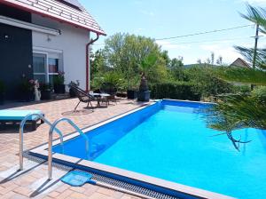 a swimming pool in front of a house at Shining Home in Felsőörs