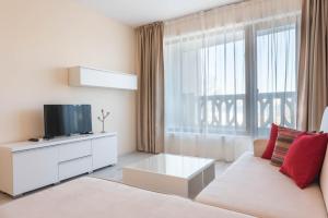 a living room with a couch and a tv and a window at Touch the sea in Varna City