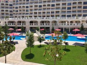 a large building with a large swimming pool and a hotel at Touch the sea in Varna City