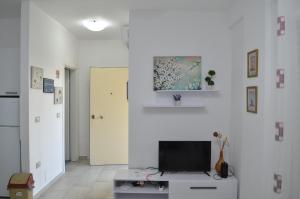 Una sala de estar con un televisor en una pared blanca. en Aquamarine Apartments 1, VLORE, en Vlorë