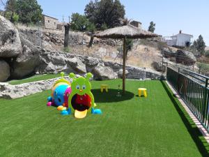 a playground with some toys on the grass at Casa Rural El Morisco in Navatalgordo +41 photos