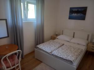 a small bedroom with a bed and a window at Plitvice Valley Apartments in Ličko Petrovo Selo