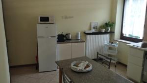 a kitchen with a white refrigerator and a table at Luce nel Garda in Castelnuovo del Garda