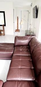 een bruine leren bank in de woonkamer bij Leribi Suites and Restaurant in Ulot