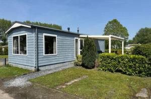 a small blue house in a yard at Recreatie Chalet in Dordrecht