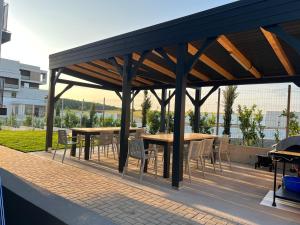 a wooden pavilion with tables and chairs on a patio at Vila Marbo in Baile Felix