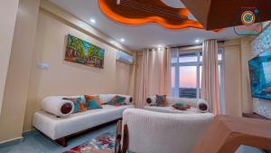 a living room with two white couches and a window at Marksman bnb in Mombasa