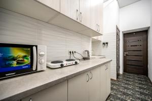 a kitchen with a counter with a microwave and a tv at Hotel No 9 in Odesa