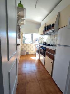 a kitchen with white appliances and a tile floor at Alojamientos Manuela 1 in Vilagarcia de Arousa