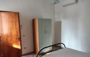 a bedroom with a bed and a wooden cabinet at Villeriunite - Villetta numero 6 in Baia Verde