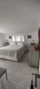 a white bedroom with a bed and a table at Alojamientos Manuela 1 in Vilagarcia de Arousa