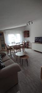 a living room with tables and chairs and a couch at Alojamientos Manuela 1 in Vilagarcia de Arousa
