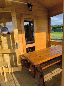 a wooden cabin with a wooden table and a door at Sielanka in Wielgie