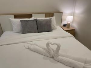 Una cama con dos cisnes hechos de toallas. en เพชรไพลินรีสอร์ทสามร้อยยอด, en Sathani Sam Roi Yot 6 fotos más