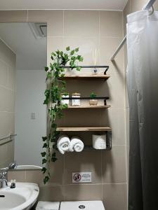 a bathroom with a sink and a toilet and towels at Le Signature in Manila