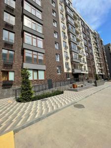 a large brick building with a tree in front of it at Квартира Фонтанка, ТРЦ Рів'єра, пляж Яхта in Fontanka