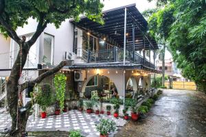 a building with a balcony and plants in a courtyard at Alaya Stays Impreza Luxury Stays in Dehradun