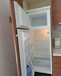 an open refrigerator with a bottle of water in it at Casa Vacanze Tirreno in Santa Marinella