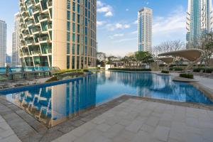 a swimming pool in a city with tall buildings at Elegant 4BR High-Rise Overlooking Burj Khalifa & Fountains in Dubai