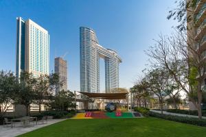 a park in the middle of a city with tall buildings at Private Room in Luxurious 3BR Apartment with BURJ KHALIFA view in Downtown near Dubai Mall in Dubai