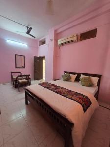 a bedroom with a large bed with pink walls at Jaisalmer Hostel Camel Castle & Safari in Jaisalmer