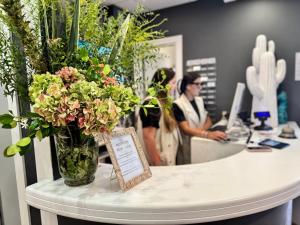 a counter with a vase of flowers on a table at Regina Urban Beach Hotel in Lido di Jesolo