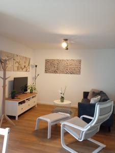 a living room with a couch and a tv at Engmels Ferienwohnung in Volkertshausen