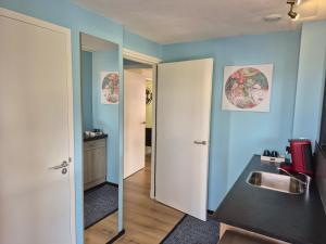 a bathroom with blue walls and a sink and a mirror at Goed Verblijf in Liempde