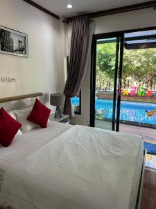 a bedroom with a bed with red pillows and a pool at 784 poolvilla พูลวิลล่า in Ban Khao Rup Chang +31 photos