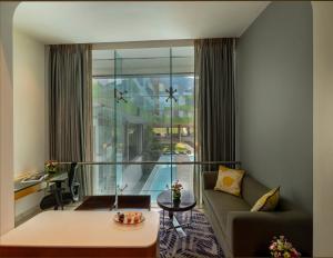 バンガロールにあるVivanta Bengaluru, Whitefieldのソファとテーブルのあるリビングルーム