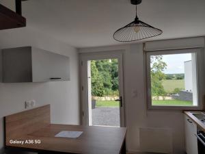 a kitchen with a table and a large window at Kity House maison individuelle avec jardin in Neufchâteau