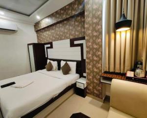 a bedroom with two beds and a chair in it at Hind palace in Lucknow