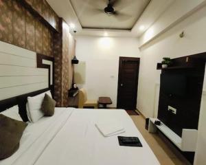 Un dormitorio con una gran cama blanca en una habitación. en Hind palace, en Lucknow 5 fotos más