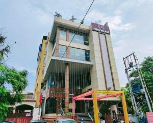 Un edificio con coches aparcados delante. en Hind palace, en Lucknow