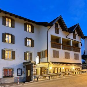 a large white building with windows on a street at Albergo Centrale in Carbonare di Folgaria
