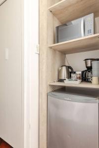 a kitchen with a refrigerator and a microwave on a shelf at Buenos Aires pleno centro, a pasos del Obelisco in Buenos Aires